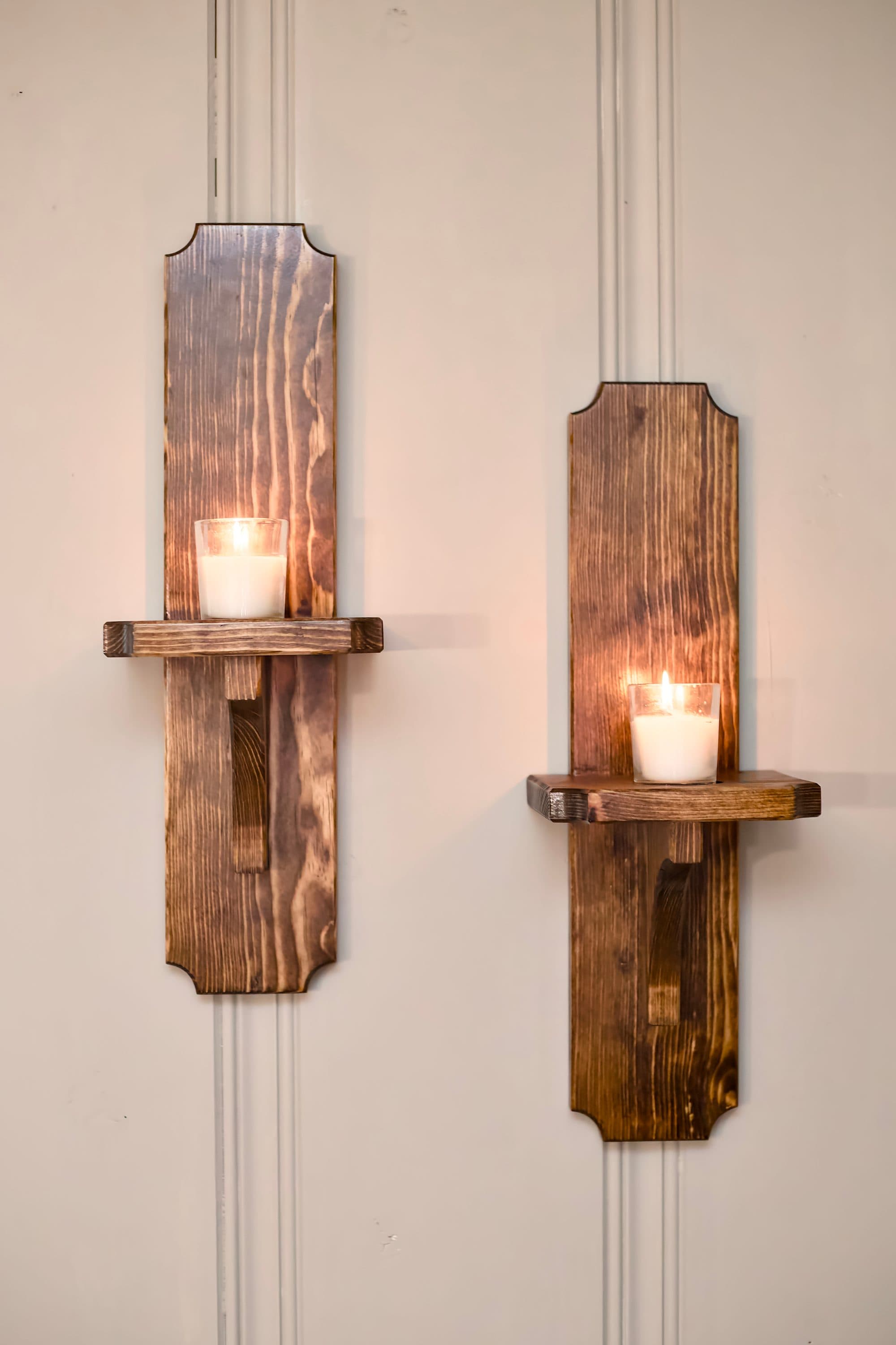 A pair of wall sconces with lit candles
